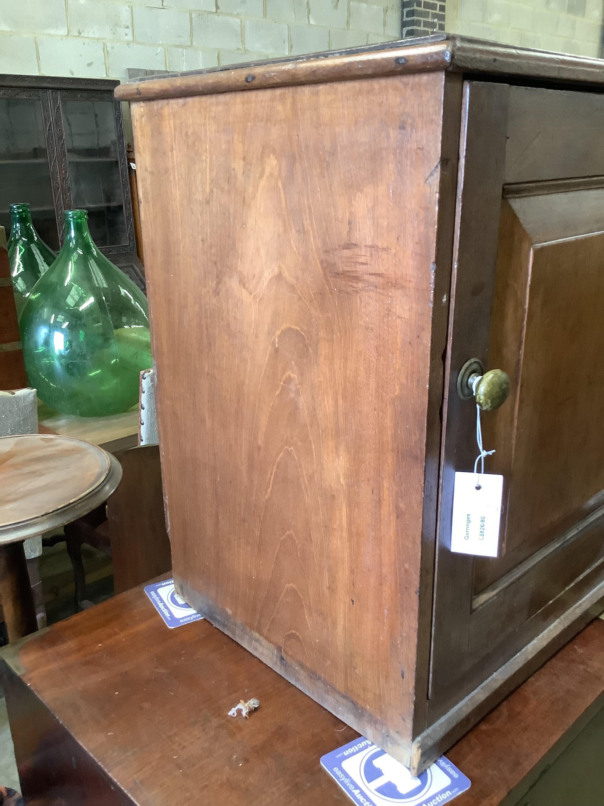 A Victorian mahogany cupboard, enclosed by a panelled door